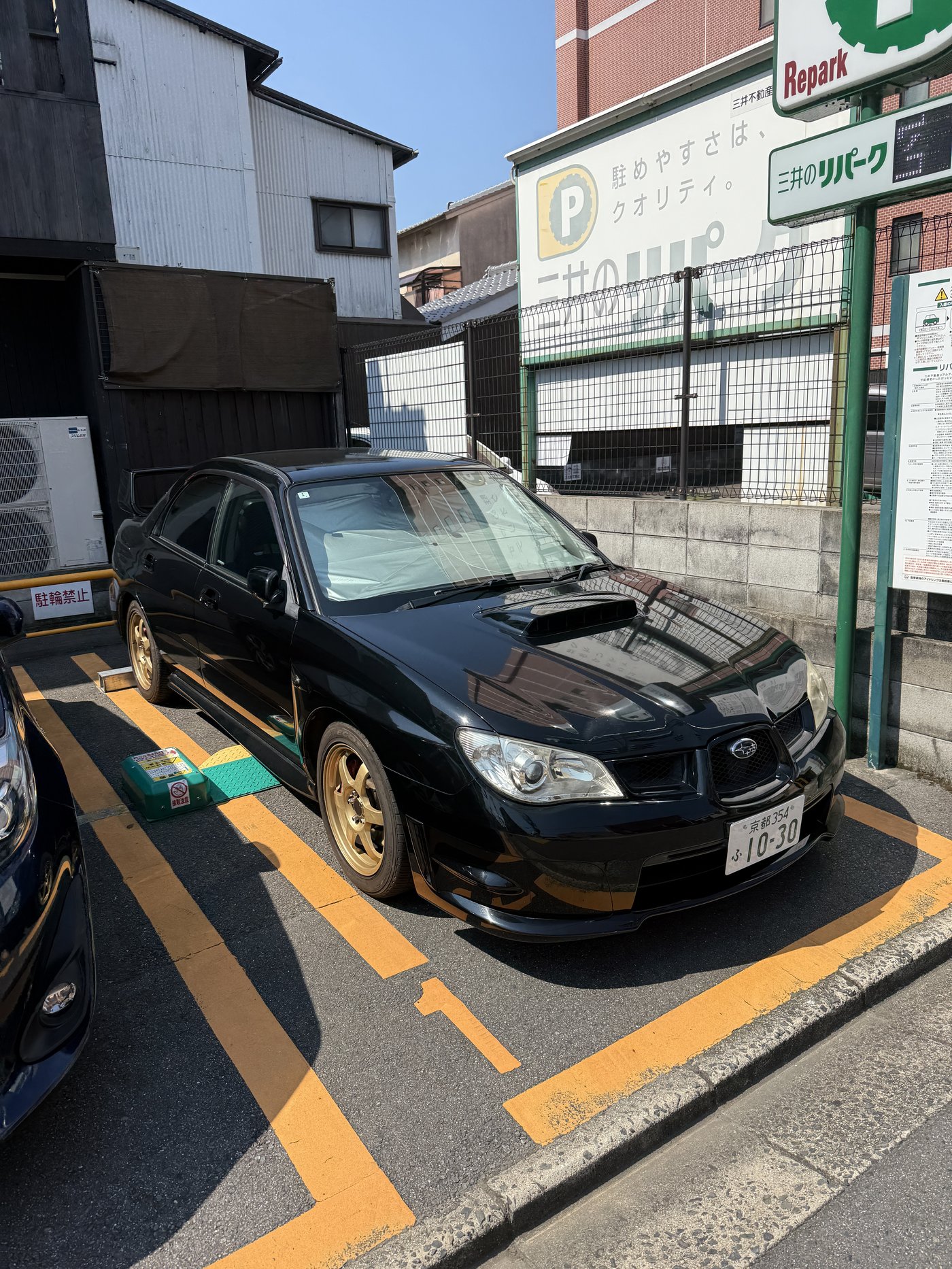 Černé Subaru Impreza WRX STI na zlatých kolech na parkovišti Repark