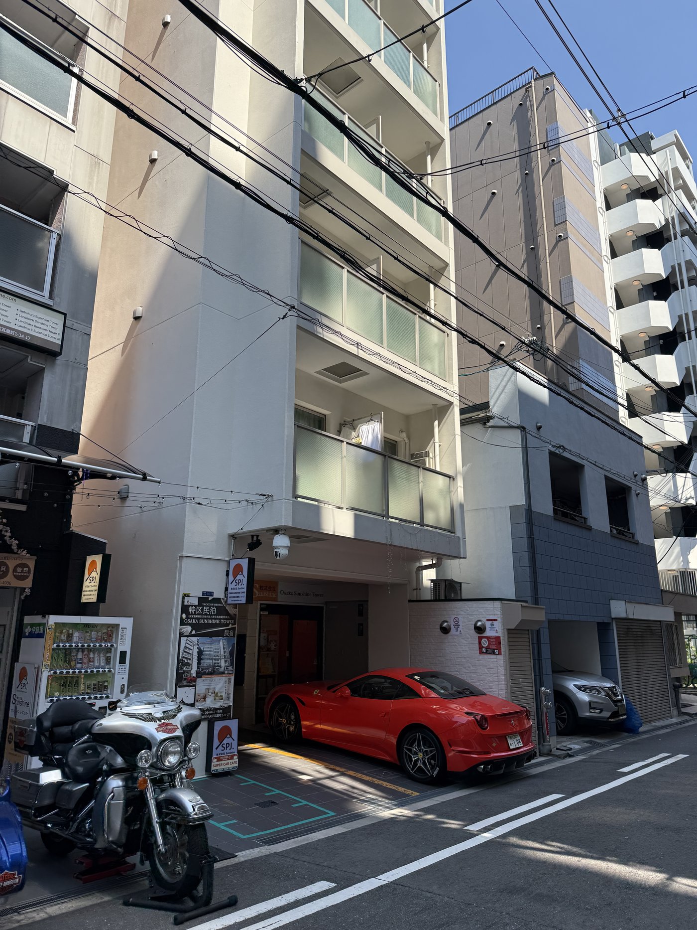 Červené Ferrari California u vchodu do Osaka Sunshine Tower